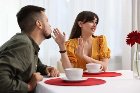 Bad date. Embarrassed woman refusing from man's kiss indoors 写真素材