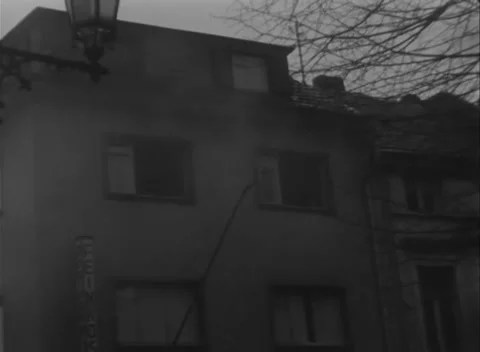 BAD GODESBERG, GERMANY - 1945: Window cloths - Uniformed men walk a wet street Stock Footage 344488121
