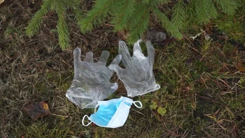 A bad man throws garbage in the forest, in the Park. disposable masks Stock Footage 142230637