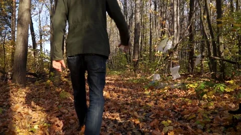 Bad man throws plastic trash in the woods Stock Footage 141898931