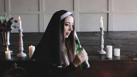 Bad nun drinking alcohol from bottle Stock Footage 72727654