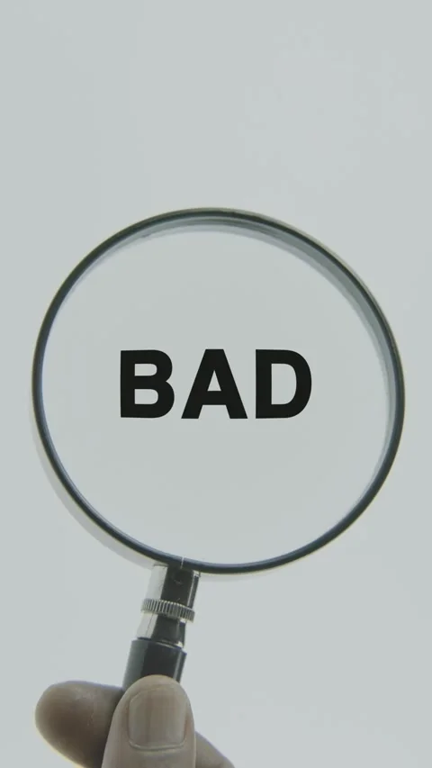 Bad text or word highlighted by a magnifying glass in a hand on a white Stock Footage 303410897