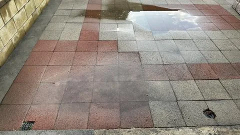 Bad workmanship on a brick patio leaving puddles Stock Photos