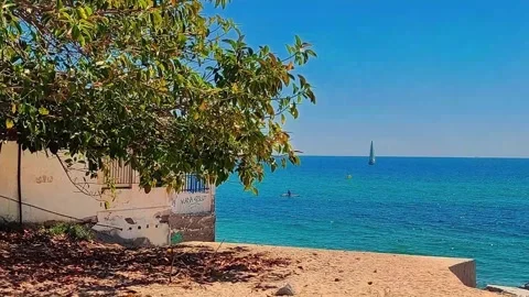 Badalona Spain 12-jun-26 Coastal House Overlooking Blue Sea With Sailboat Stock Footage 336823522