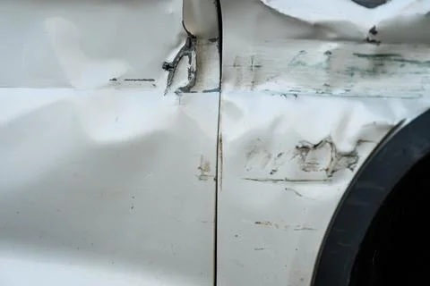 Badly crashed side of a white car Stock Photos