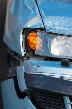 Badly damaged front light and bumper of a blue car Stock Photos