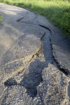 Badly eroded dirt road with deep cracks and washed out soil after heavy rain Foto stock