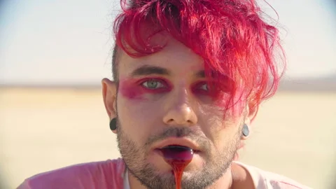 Badly wounded young man with red dyed hair choking and coughing up blood. Stock Footage 293114959