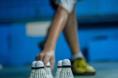 A badminton player is practicing footwork by moving the shuttlecock Stock Photos