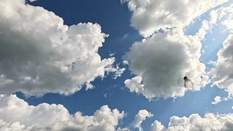 Badminton racket hits shuttlecock against blue sky with bright clouds. Stock Footage 319129248