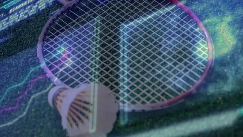Badminton racket lying flat beside shuttlecock on green court featuring neon Stock Footage 307457314