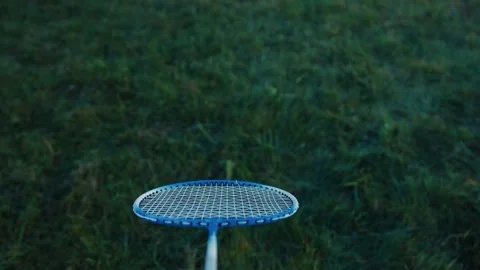 Badminton racket stuck in grass during outdoor game Stock Footage 318585609