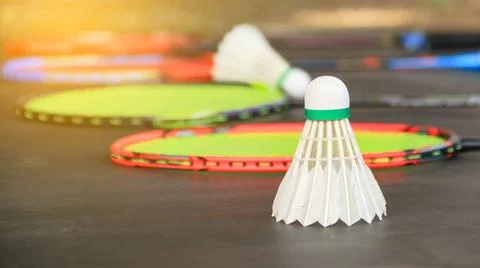 Badminton shuttlecocks with rackets on a dark background symbolizing the sp.. Stock Photos