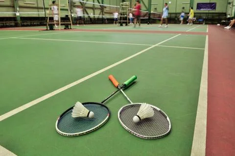 Badminton - two shuttlecocks on rackets in the badminton courts with players Fotos Stock