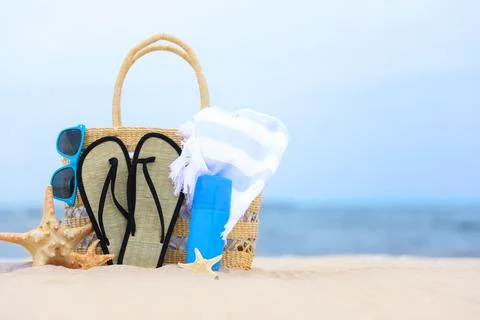 Bag and beach objects on sand near sea, space for text Foto stock