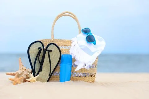 Bag and beach objects on sand near sea Stock Photos