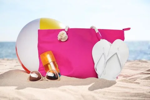 Bag and beach objects on sand near sea Stock Photos