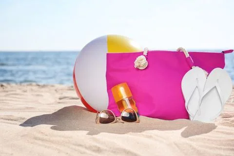 Bag and beach objects on sand near sea, space for text Stock Photos