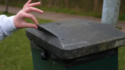 A bag of dog poo is put in a bin Stock Footage 127598569