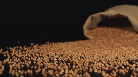 Bag falls on a table and a buckwheats scatter out it Stock Footage 59015993