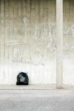 Bag of garbage leaning against wall Stock Photos
