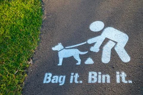 Bag it Bin it painted sign on footpath, encouraging dogs owners to clear up a Stock Photos