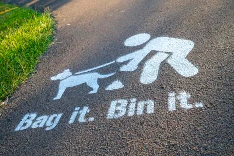 Bag it Bin it painted sign on footpath, encouraging dogs owners to clear up a Stock Photos