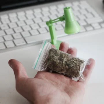 Bag with a marijuana in hand Stock Photos