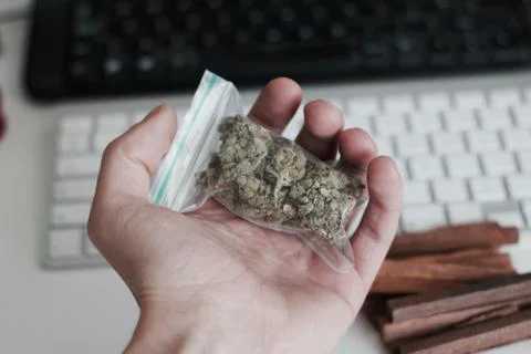 Bag with a marijuana in hand Stock Photos