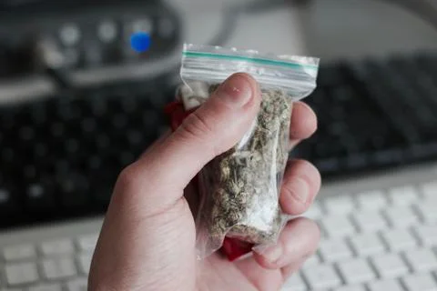 Bag with a marijuana in hand Stock Photos