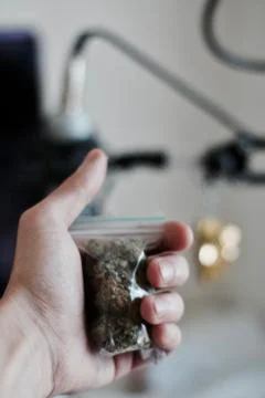 Bag with a marijuana in hand Stock Photos