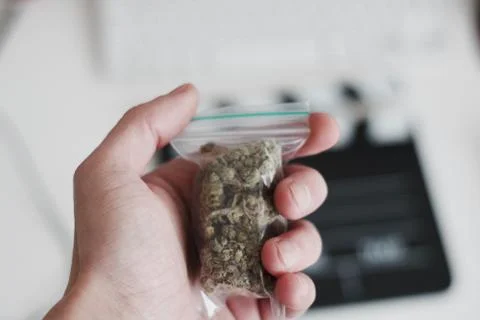 Bag with a marijuana in hand Stock Photos