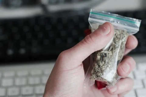 Bag with a marijuana in hand Stock Photos