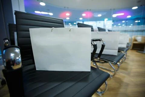 Bag with a premium gift inside is standing on a chair at the event Stock Photos