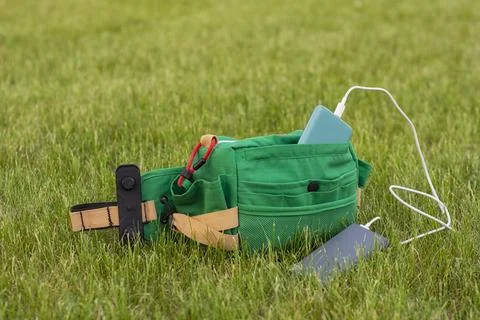 Bag with a smartphone is charged using a power bank. Portable charger in nature Stock Photos