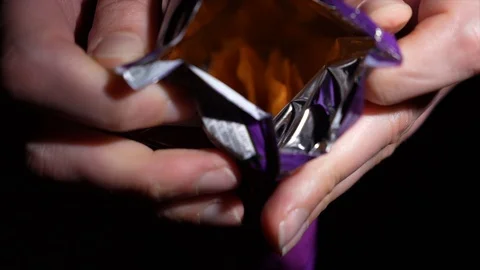 Bag of tortilla cheese chips opened slow motion Stock Footage 129275392