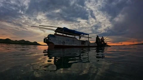 Bagan Fishermen Casting Nets at Sunset in Traditional Indonesian Waters Stockbeeldmateriaal 341298090