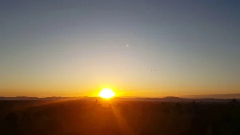 Bagan landscape at sunset, sun descends on horizon, pagodas in distance, birds Vídeos de archivo 78848833