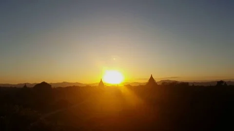 Bagan landscape at sunset, sun descends on horizon, pagodas in distance, Myanmar Видео 79137009