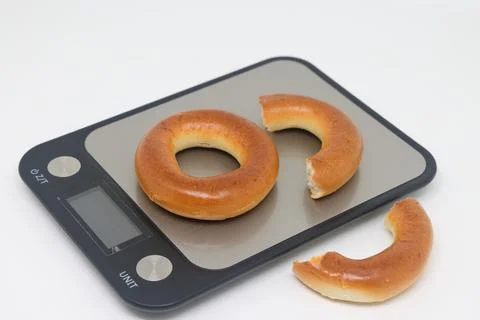 Bagels sit on an electronic kitchen scale, placed on the scales, proper nut.. Stock Photos