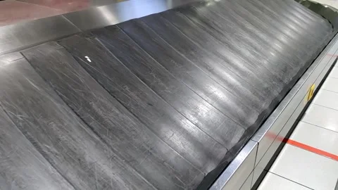Baggage claim area features empty conveyor belt at airport terminal 스톡 동영상 302564206