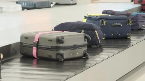 Baggage claim process at an airport showing luggage on a carousel Stock Footage 339323566