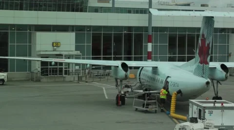 A baggage handler loads luggage onto airplane Stock Footage 42114506
