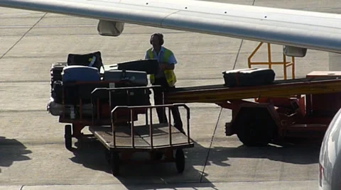 Baggage Handler offloading luggage, from an aircraft Video stock 36546201