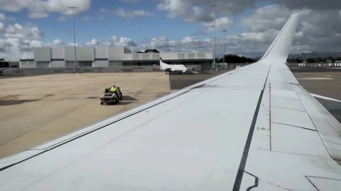 A baggage handler waiting for an aircraft to stop on the airport tarmac Video stock 238914357
