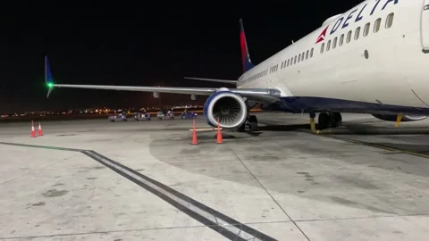A Baggage Tug Passes Behind A Plane Stock Footage 145660080