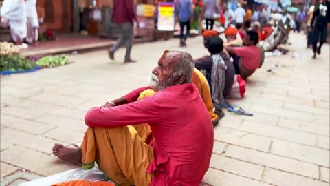 An Bagger elderly man sits calmly on the streets of India Stock Footage 285421153