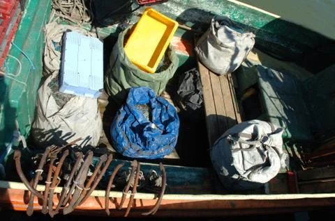 Bags with nets and other thing on small and old fishing vessel. Stock Photos