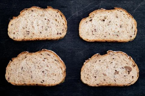 Baguette bread sliced pattern isolated black wood background. Stock Photos