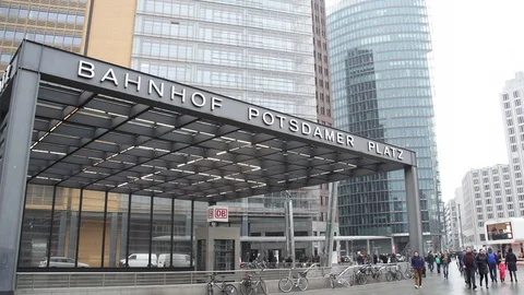 Bahnhof Potsdamer Platz on a cloudy winter day while people walk in background Stock Footage